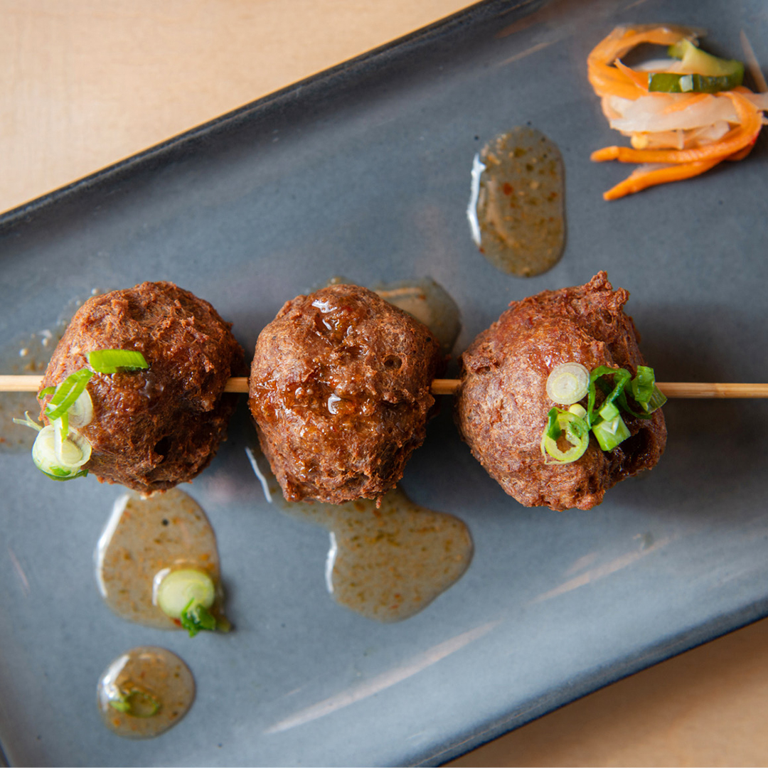 3 boulettes de bœuf frites servies avec une sauce épicée au miel.