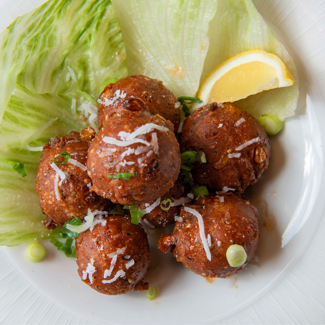 Boulettes Phnom Penh à base de maïs, de noix de coco et d'oignons verts, assaisonnées au cajun et à la feuille de lime kaffir.