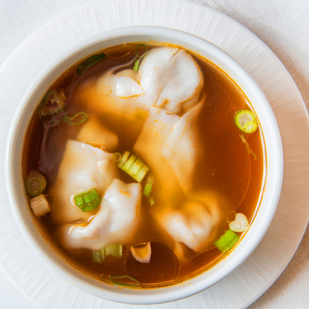 Soupe à base de bouillon de poulet avec wonton de porc, garnie d'oignons verts et de coriandre.